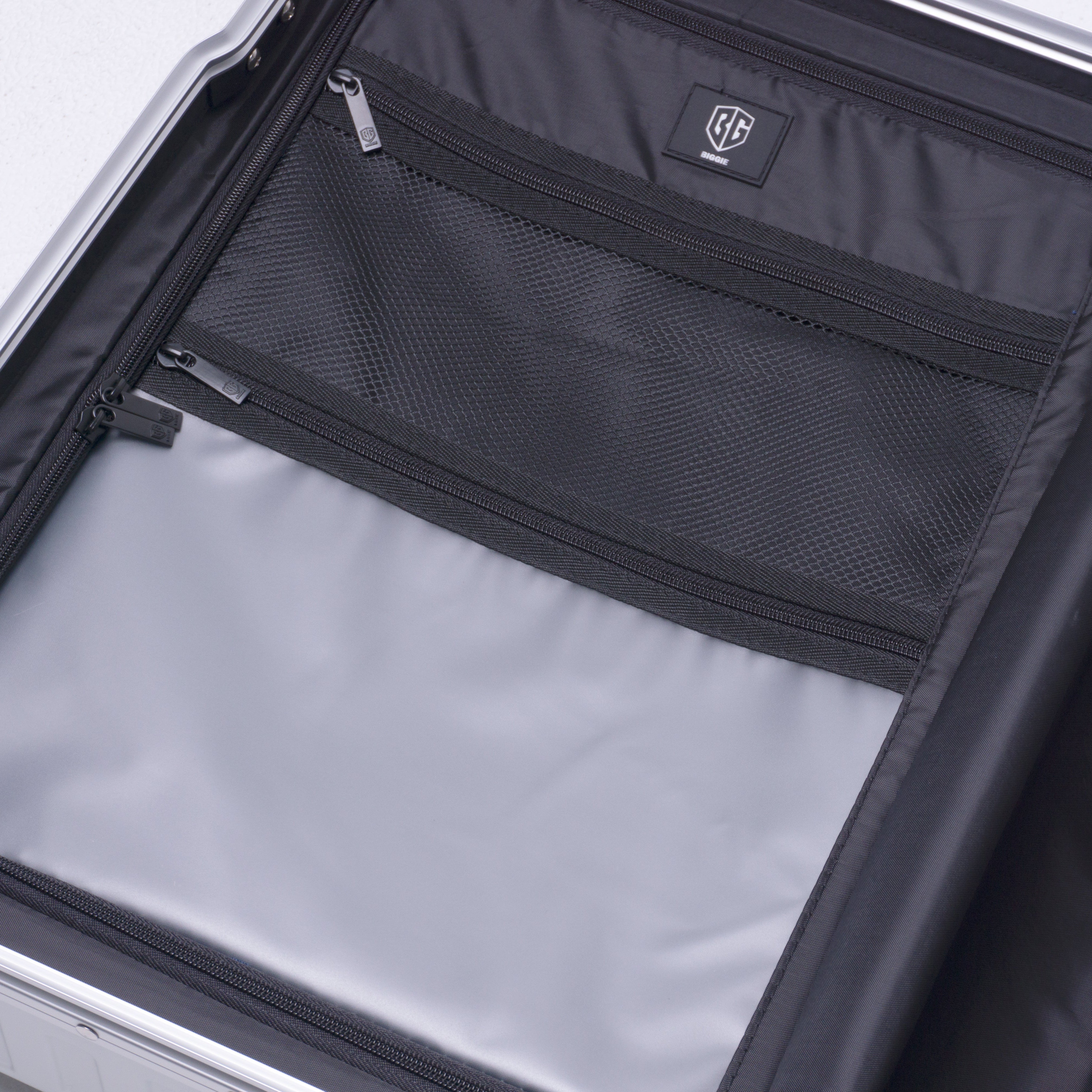 Open suitcase with black interior pocket and visible brand logo.