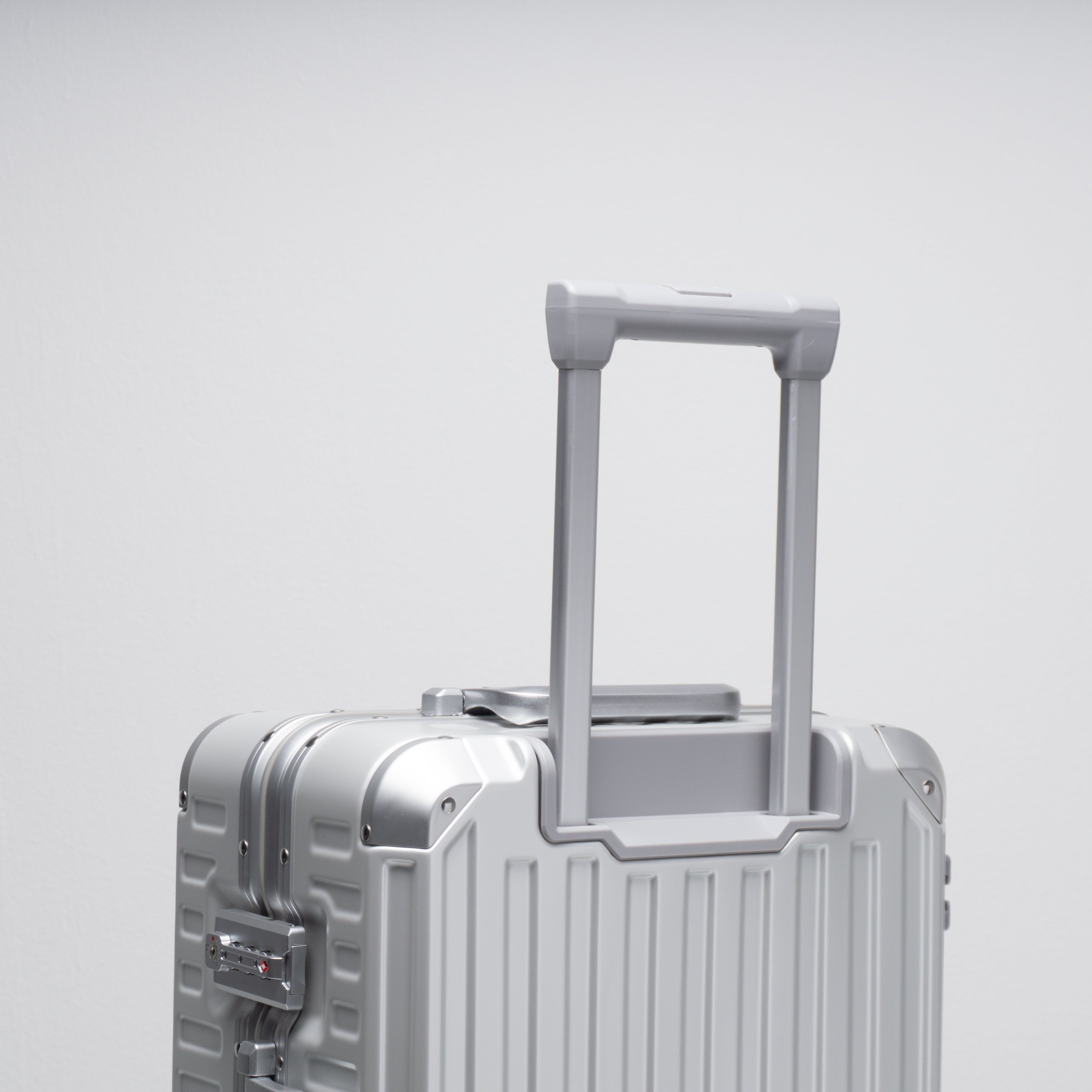 Silver suitcase with a handle on a light gray background