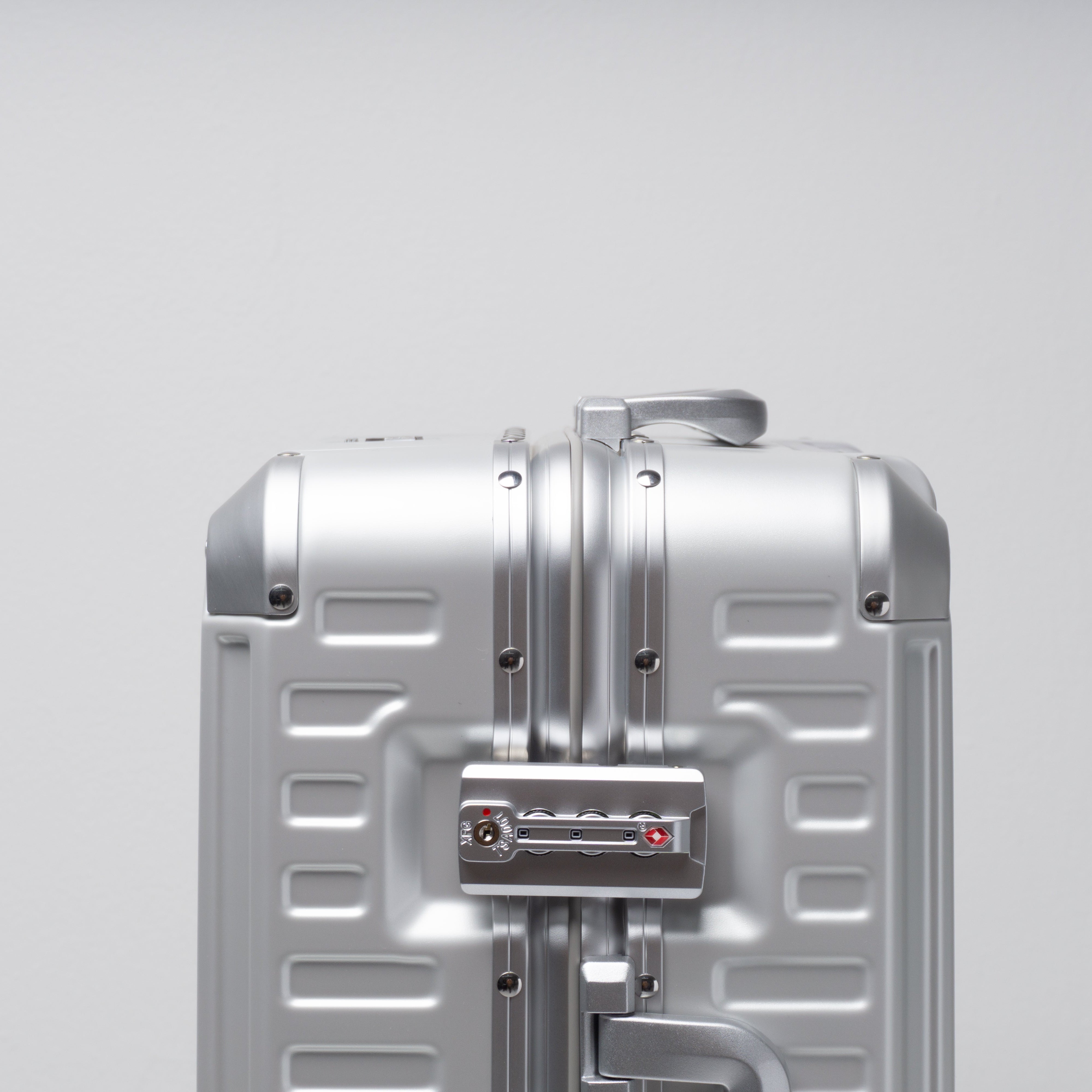 Silver suitcase on a light gray background
