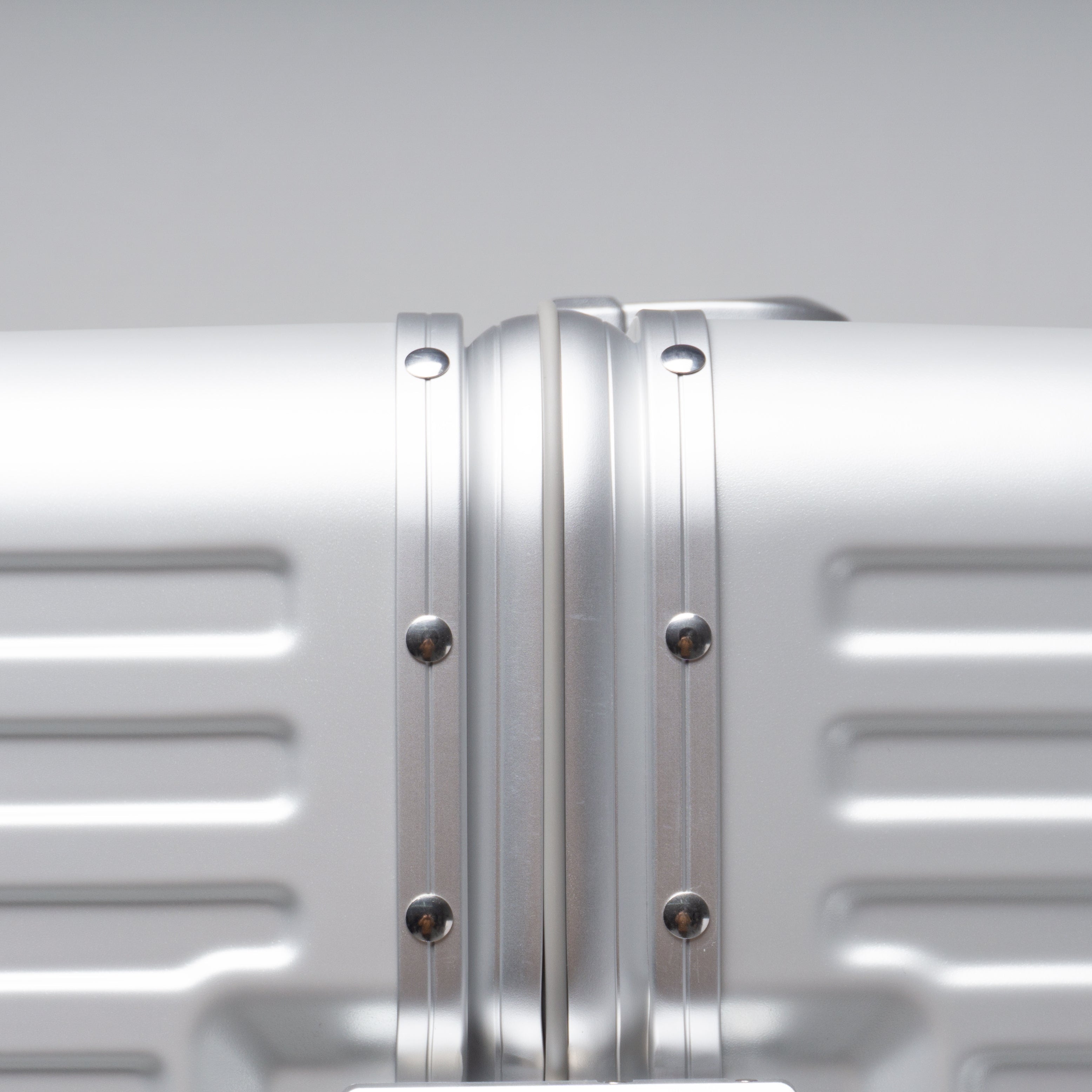 Silver suitcase with a visible brand logo on a gray background